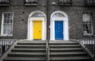 Two front doors on condos, one blue and one yellow.