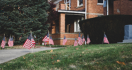 An image of a yard with flags used to demonstrate how to get into rent to own.