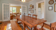 A large wooden table and chairs set in a blue dining room, a house you can rent or buy.